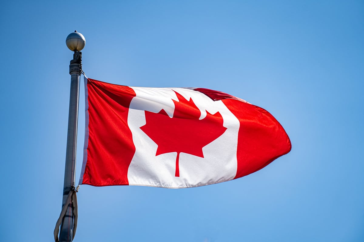 View of Canadian flag waving in clear blue sky
