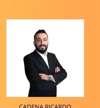 Professional headshot of Cadena Ricardo, man in black blazer with arms crossed against white background, orange border